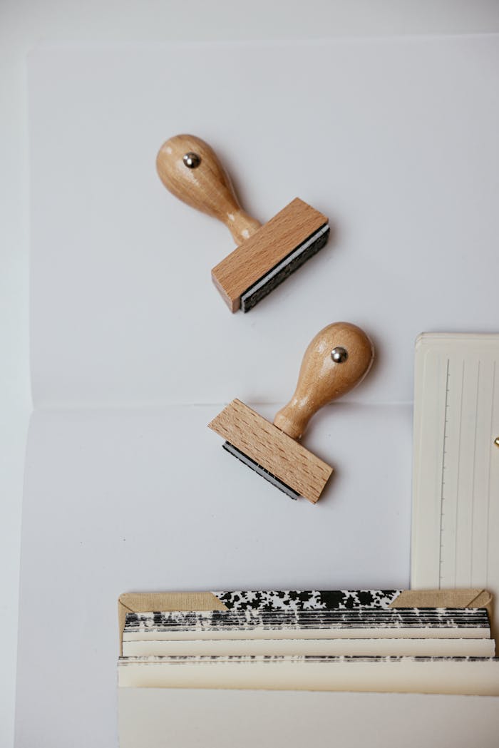 hero-img-01 Top view of two wooden rubber stamps and papers, perfect for office themes.